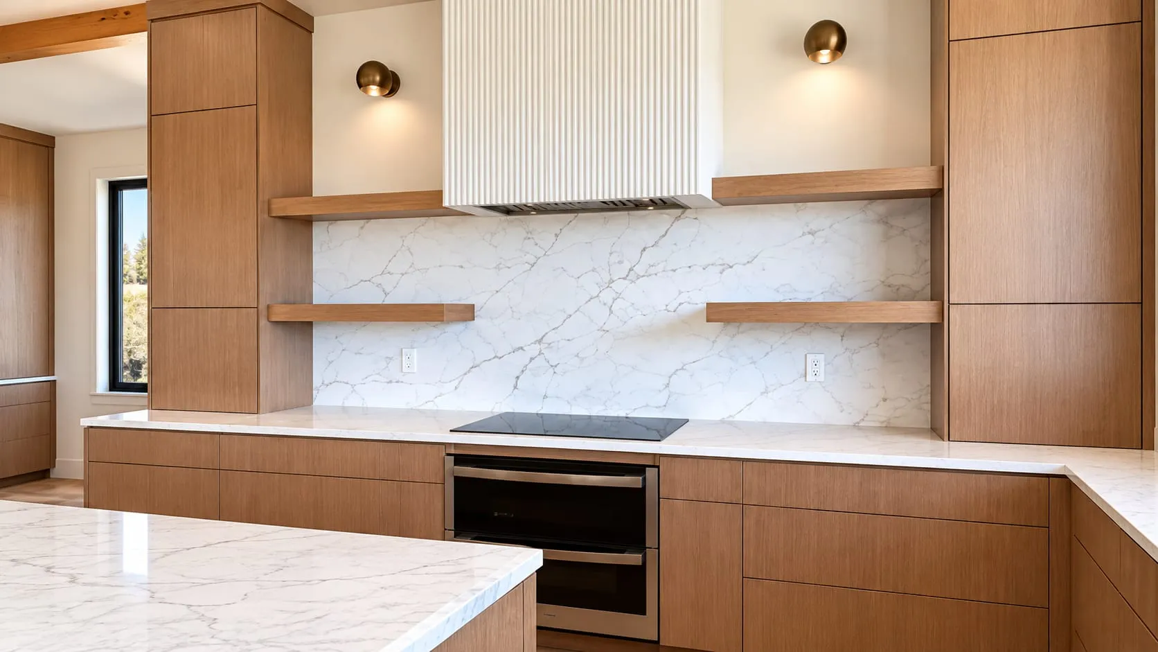 Kitchen with wood cabinets and a veined white stone countertop and full-height backsplash behind the cooktop
